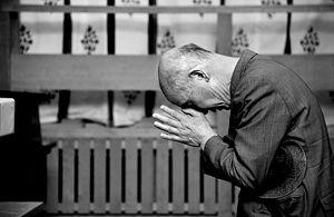 A man praying at a Japanese Shintō shrine.