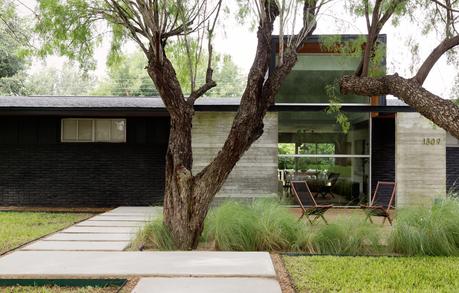 Modern Texas home with concrete beam overhang at entrance.