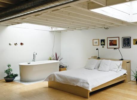 Joint bathroom and bedroom with a Neptune bathtub and wall art
