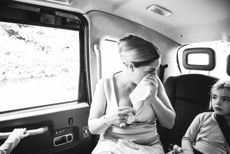 Bride wipes away a tear on the way to ceremony
