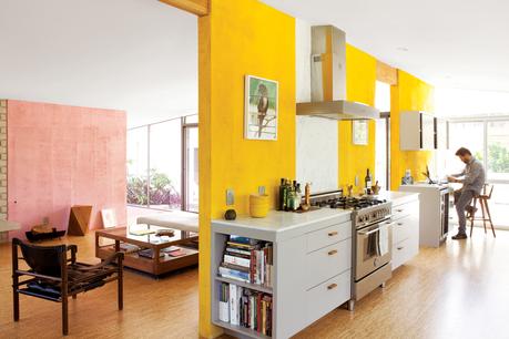 Modern kitchen with yellow sectioned walls and monochrome appliances 