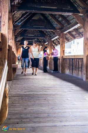 People crossing Lucerne's medieval wooden bridge 