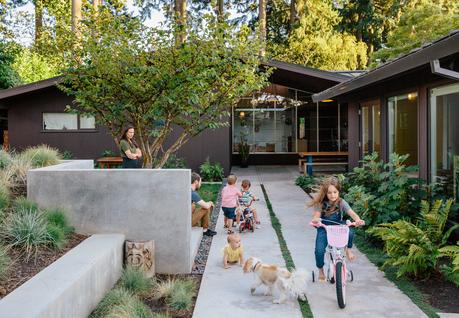A concrete courtyard surrounds the family in this midcentury modern renovation. 