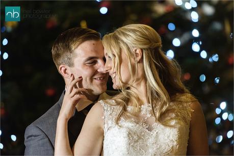 bride and groom by a christmas tree