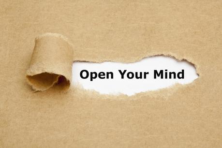 Open Your Mind appearing behind torn brown paper.