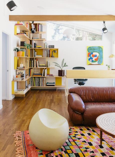 A home office in Portland features colorful built-in bookshelves. 