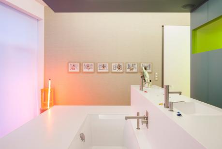 Corian sinks, Ritmonio fixtures, and glowing artwork in bathroom.