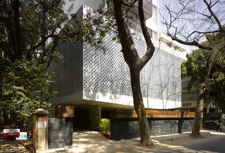 The entrance leads to an open walkway, sitting area and mail area beneath the open-air public floor of the building.