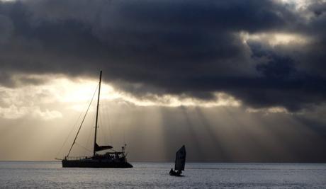 catamaran opti silhouette with clouds on the ocean