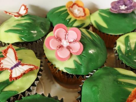 matching cupcakes for 60th birthday cake green grass with fondant flowers and butterflies