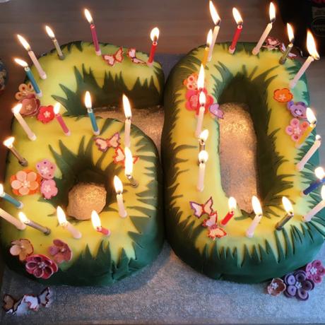 60th birthday cake flowers and grass with candles burning