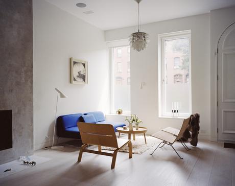 The living room is furnished with designs from Fritz Hansen, Muuto, Louis Poulsen, and Living Divani. 