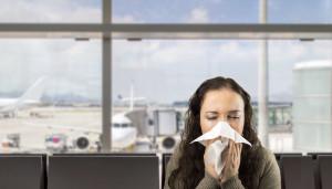 sick woman sneezing at the airport
