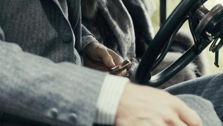 Peaky Blinders – Tommy’s Gray Striped Flannel Suit Tommy checks the time while waiting in his Ford with Mrs. Kimber.