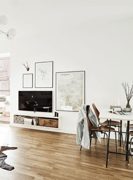 Scandinavian Style Living Room With TV Hanging Over Floating Shelf