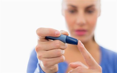 A diabetic woman takes skin-prick test to check her blood sugar levels