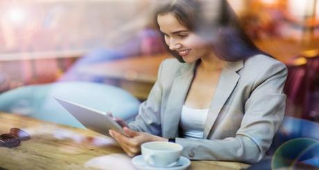 Woman using digital tablet in cafe