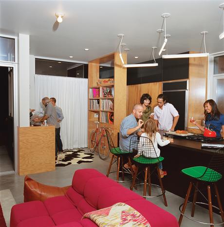 A music and cycling fan (the vintage bike is by Vivalo), Grunbaum mans the turntables while friends gather in the kitchen. Case Study barstools are from Modernica.