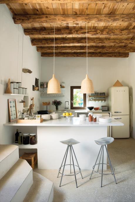 Modern kitchen with Pepe Cortès barstools and restored wooden beams