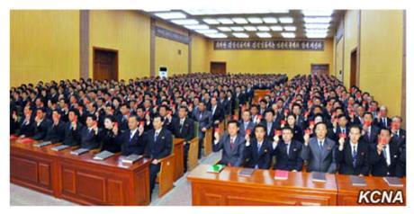 Party representatives hold up their party membership credentials during the Raso'n party conference (Photo: KCNA).