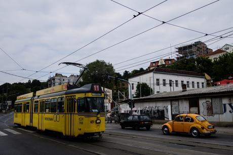 A bit of history here, a yellow tram passes a yellow VW beetle and a Yugo car! 