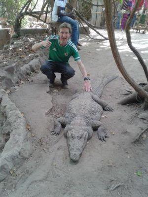 Stroking Crocodiles at Kachikally Pool, Bakau, The Gambia Stroking Crocodiles at Kachikally Pool, Bakau, The Gambia