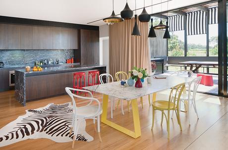 modern lakeside home in Australia kitchen and dining area with tom dixon pendant lamps and steel and marble dining table by chris connell 