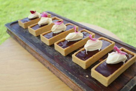 Salted caramel and hazelnut chocolate tarts with clotted Barambah Dairy cream, fresh berries from Cove.