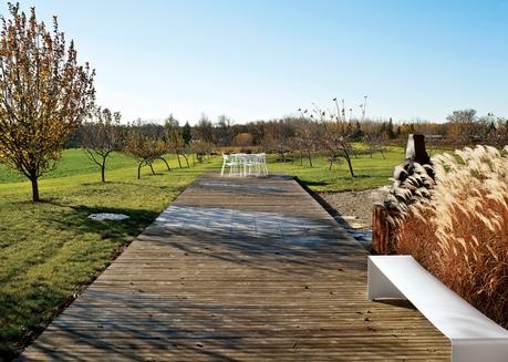 Wooden decking with white bench, chairs, and table