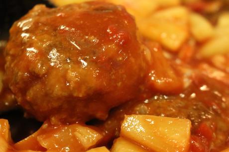Sweet and Sour Meatballs - meatballs simmering in the sweet and sour sauce close up