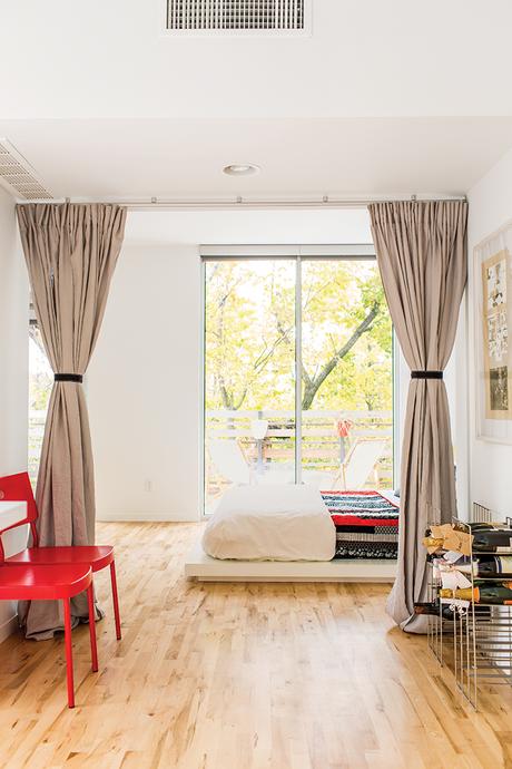 Affordable Kansas City home with west elm bedding and platform bed along with ikea chairs in the bedroom