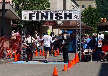 Mike Sohaskey high-fiving Hatfield & McCoy at finish