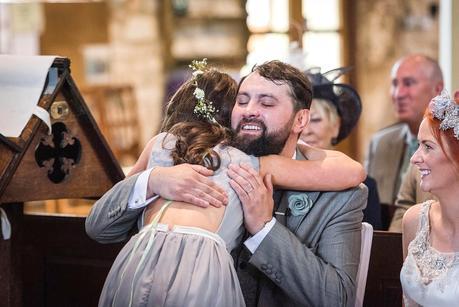 groom hugging a flower girl