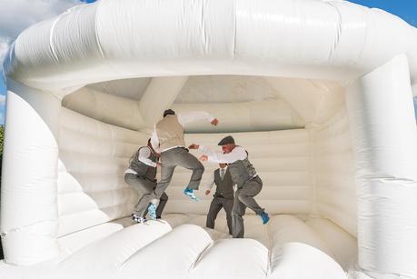 groom on bouncy castle at a rustic wedding