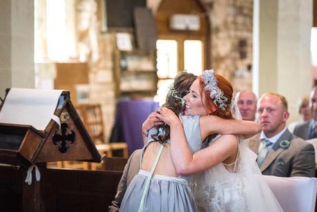 bride hugging a flower girl 