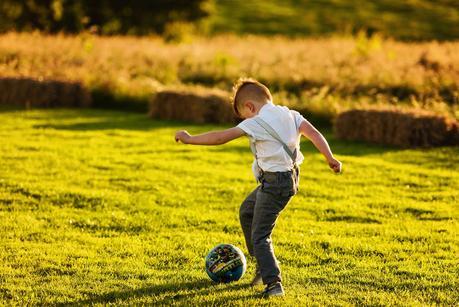 little boy kicking a ball at a wedding 