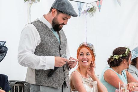 A red haired bride smiling at the groom