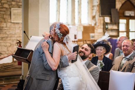 bride hugging her father after his wedding reading 