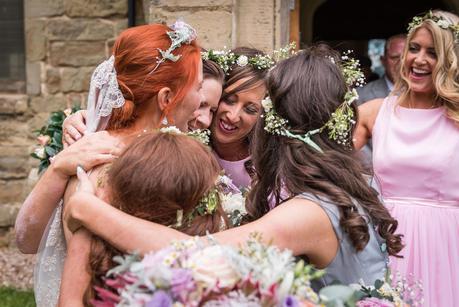 a bride in a group hug with her bridesmaids 