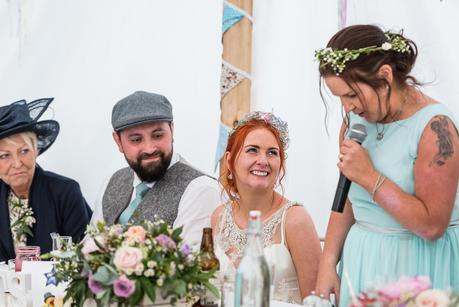 bride smiling at her sisters wedding speech