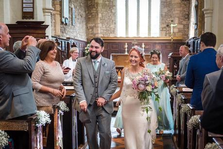 bride and groom walking out of hillmorton church