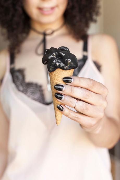 girl holding black coconut ash ice cream with black nail polish