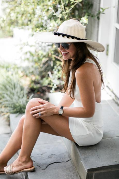 Amy havins wears a white romper and a custom floppy hat.