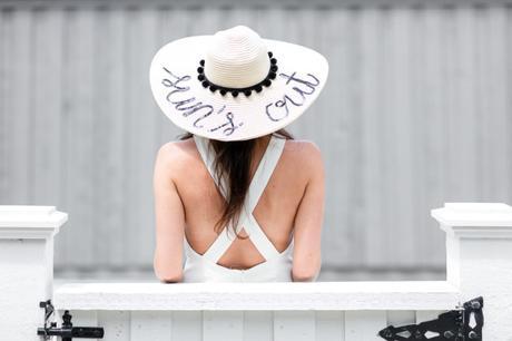 Amy havins wears a white romper and a custom floppy hat.