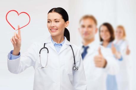 smiling female doctor pointing to heart