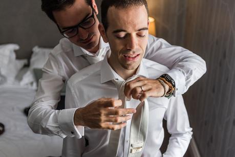 groom having his tie adjusted