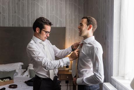 an usher adjusting the grooms tie