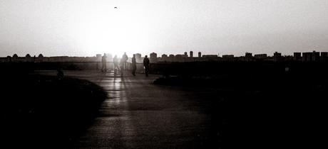 The setting sun casting long shadows at Belgrade Fortress with the skyline of Novi Beograd in the background