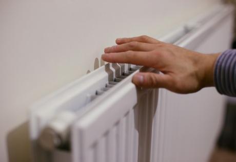 A hand checking the heat of a radiator