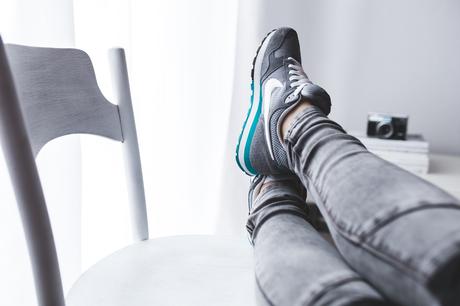 Lady putting her feet up on a chair wearing nike